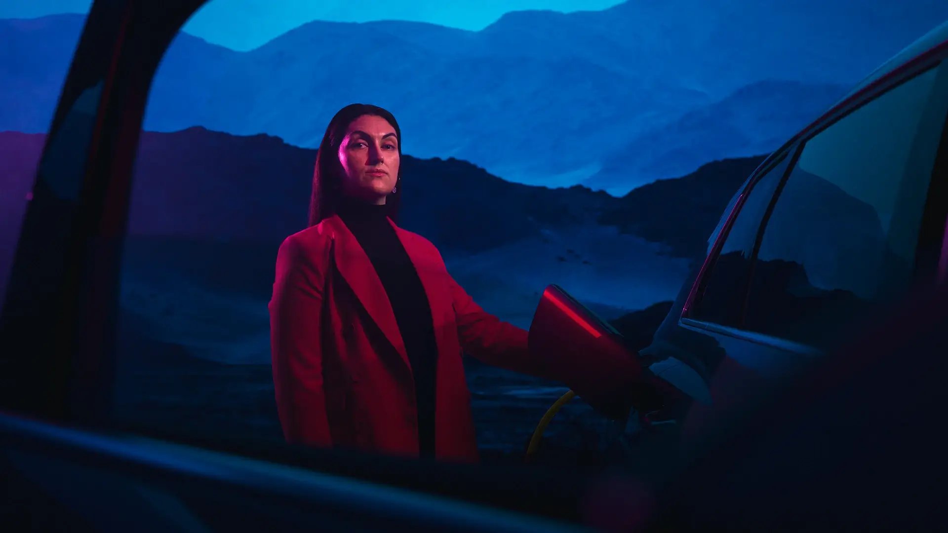 Professional woman EV charging blue night sky