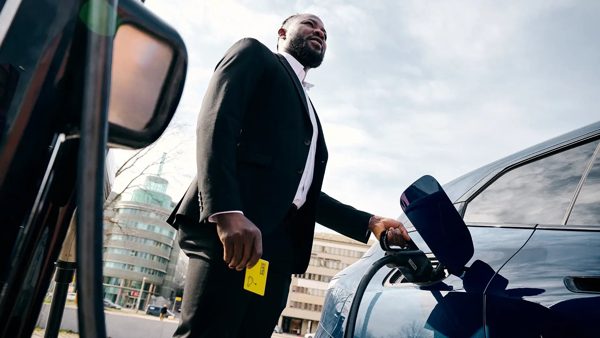 Businessman charging electric car city