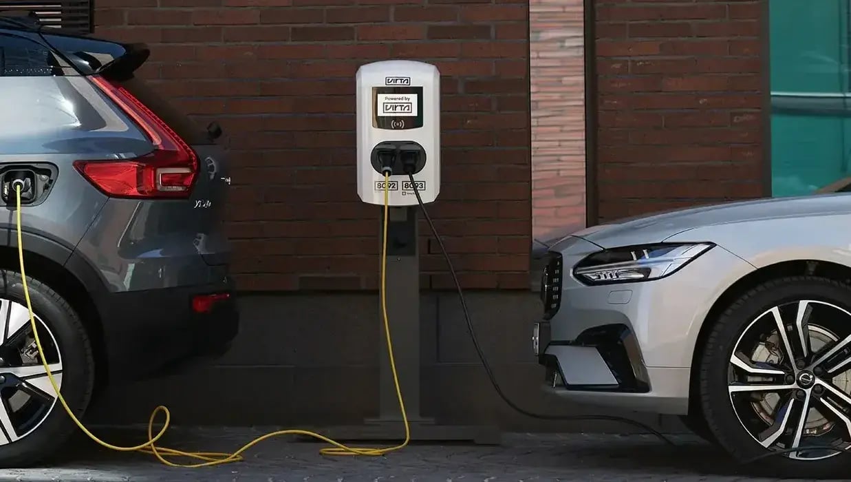 two-electric-cars-ac-charger-brick-wall-city-2
