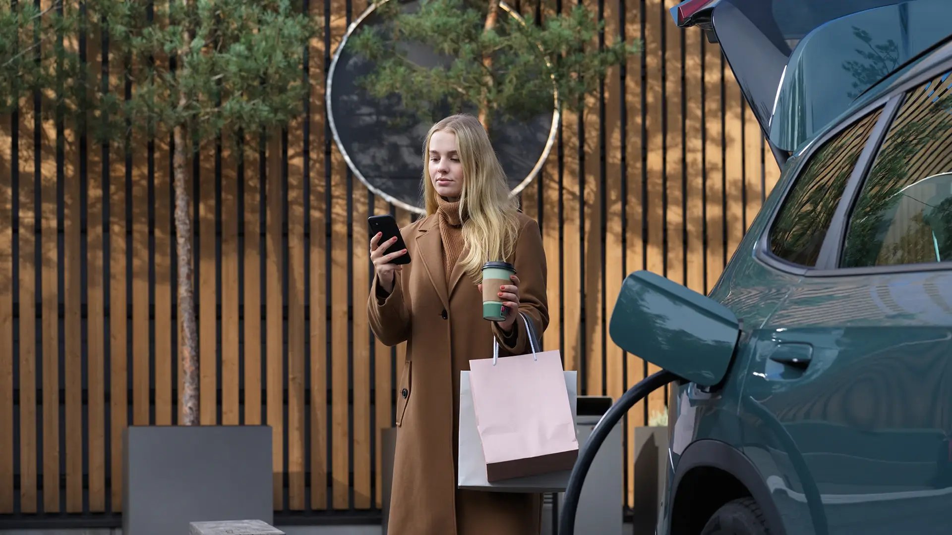 Woman managing EV charging app while charging electric vehicle