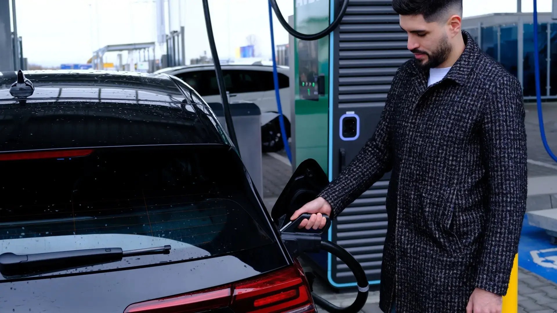 man-charging-ev-at-alpitronic-fast-charger-at-avex-charging-hub