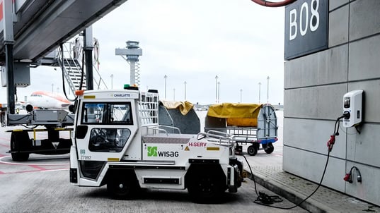 Electric luggage vehicle charging at AC charger at airport