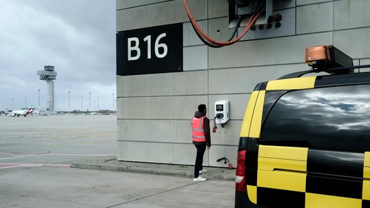 Man standing at AC charger at gate B16
