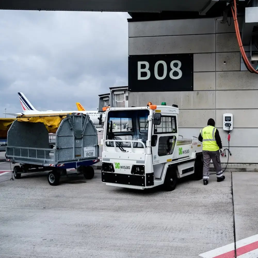 BER Aeroporto di Berlino Brandeburgo Impiegato di un treno elettrico che si ricarica presso una stazione di ricarica Virta sul piazzale dell'aeroporto.
