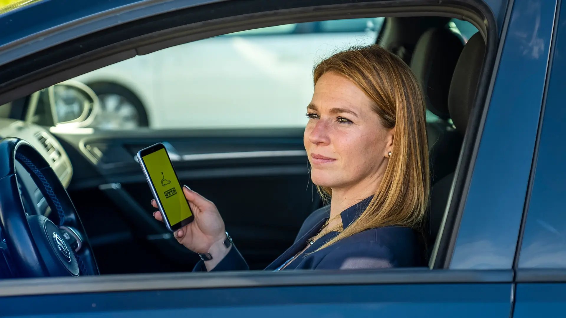Woman using smartphone in electric car