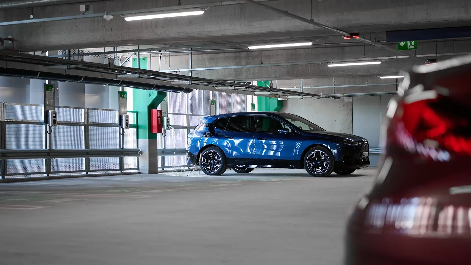 Blue SUV electric vehicle at charging station in parking garage
