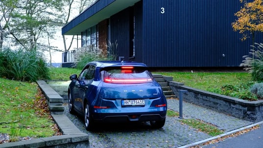 Blue EV parked beside hotel