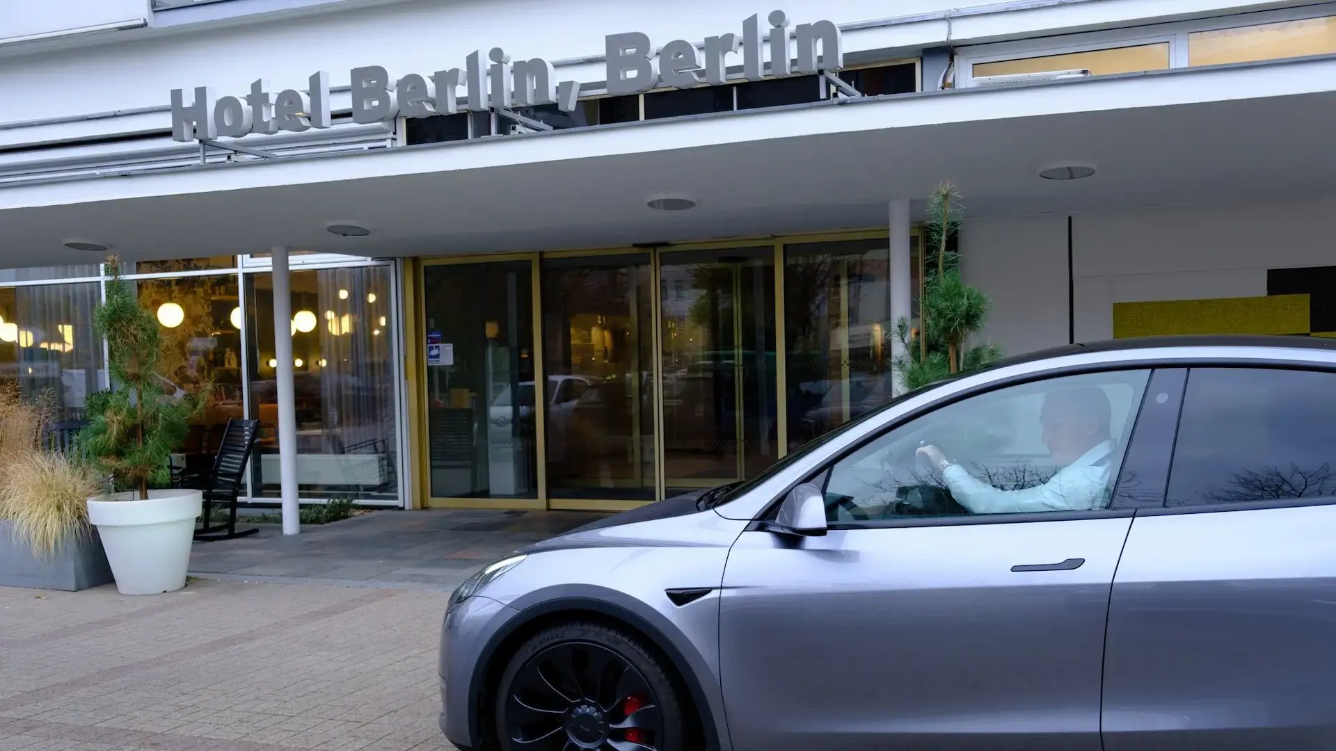E-Auto fährt am Eingang des Hotel Berlin Berlin Teil der Pandox Gruppe vorbei