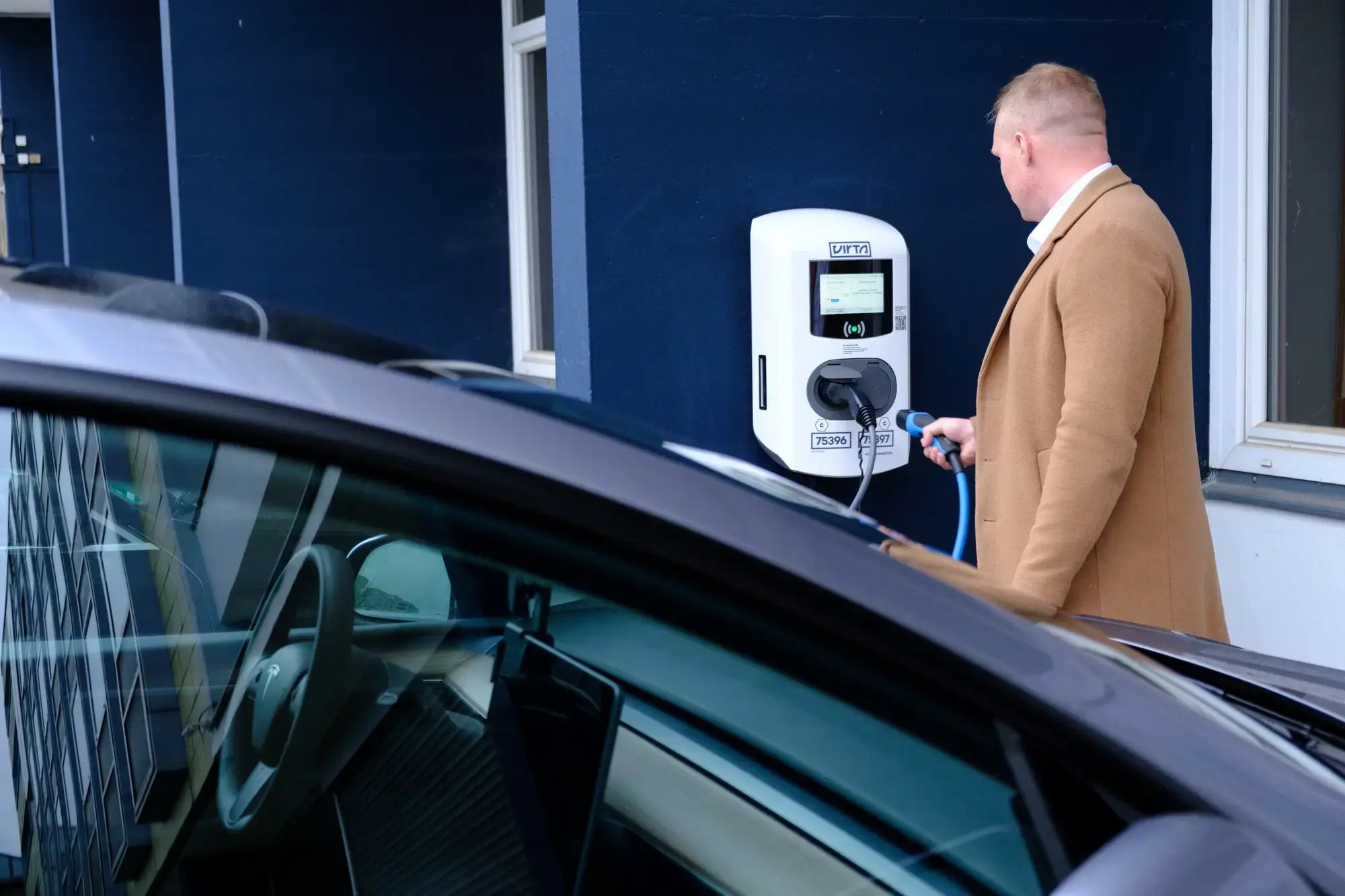 Mann lädt E-Auto am Hotel Berlin Berlin Teil der Pandox Gruppe