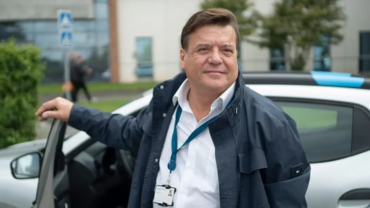 Man standing beside an EV with an open door