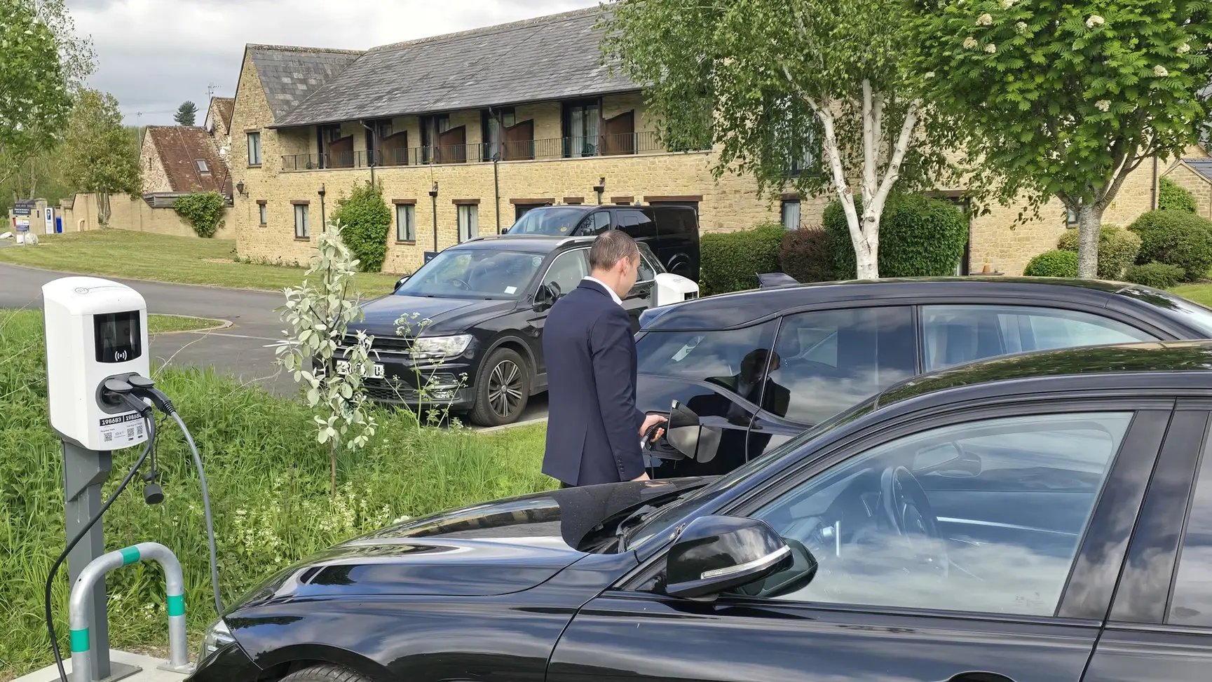 man-charging-ev-next-to-ac-alfen-charger