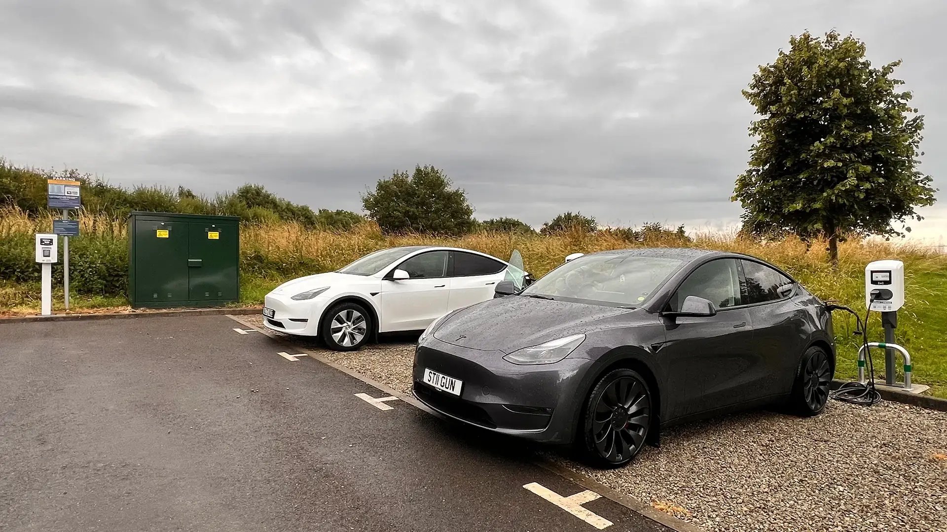 Two Tesla EVs charging at an AC charging site with Virta's Payment Kiosk