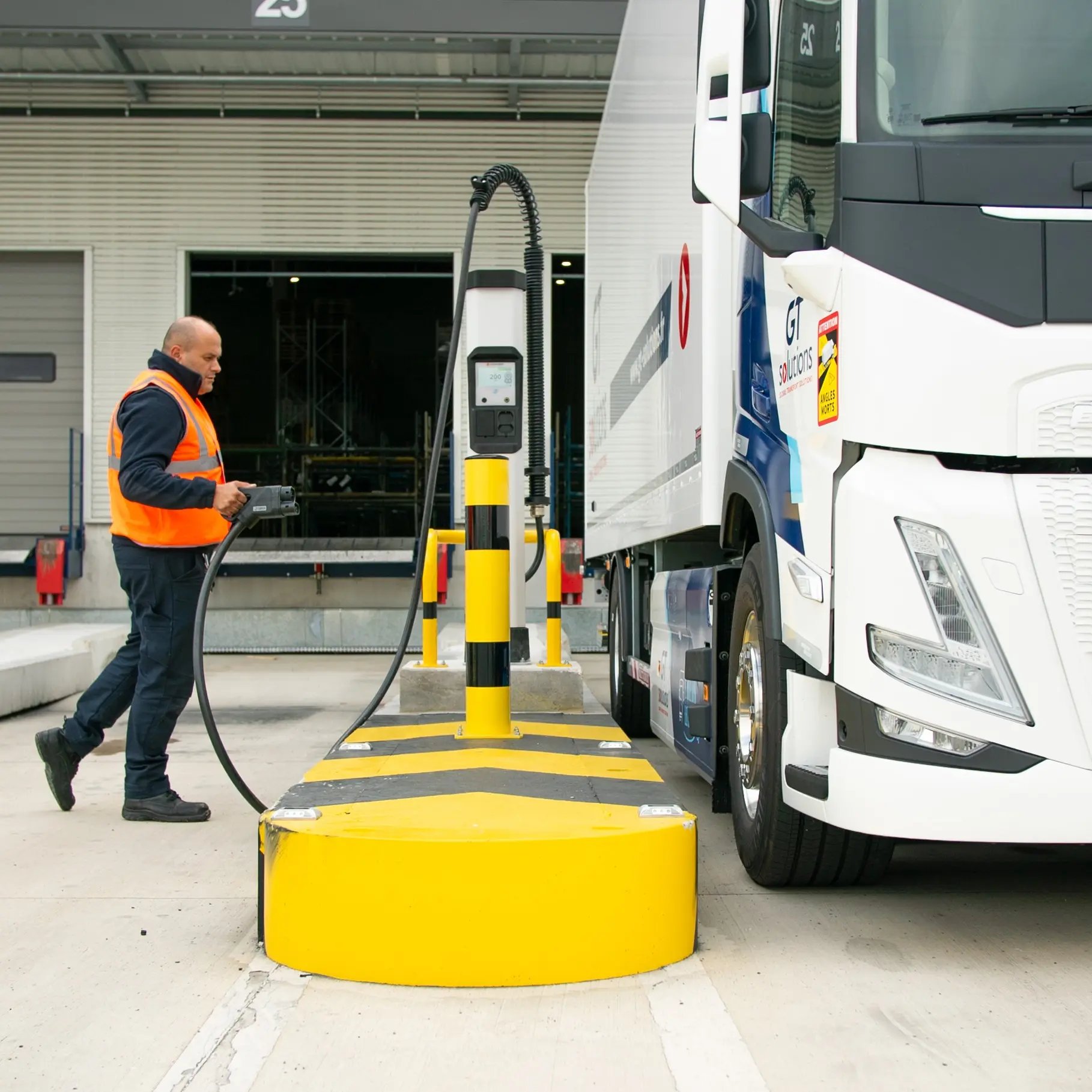 Man in orange vest charging electric truck