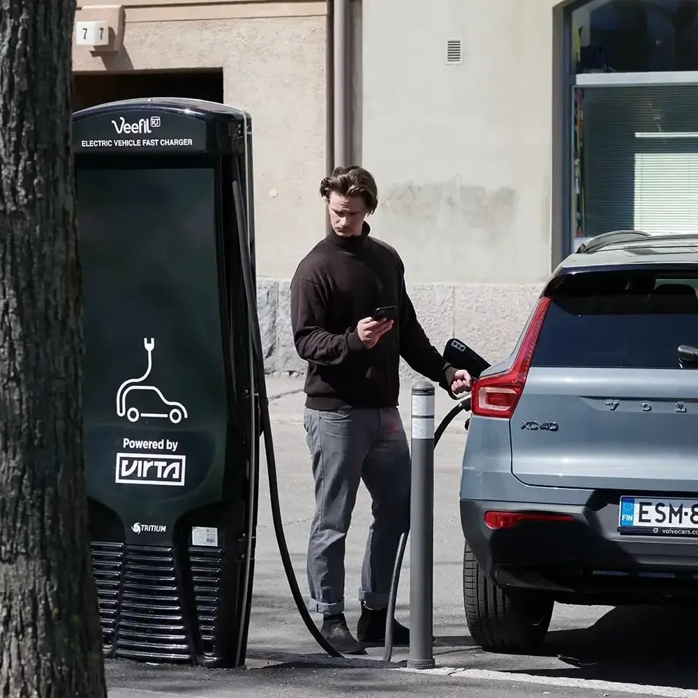 Man using Virta EV fast charger on street