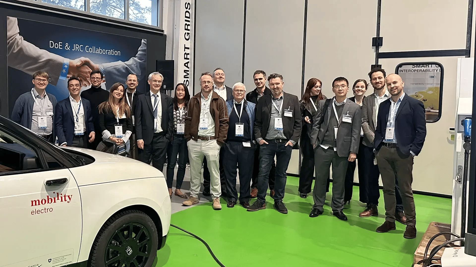 People från Task 53 standing between an EV and an EV charger