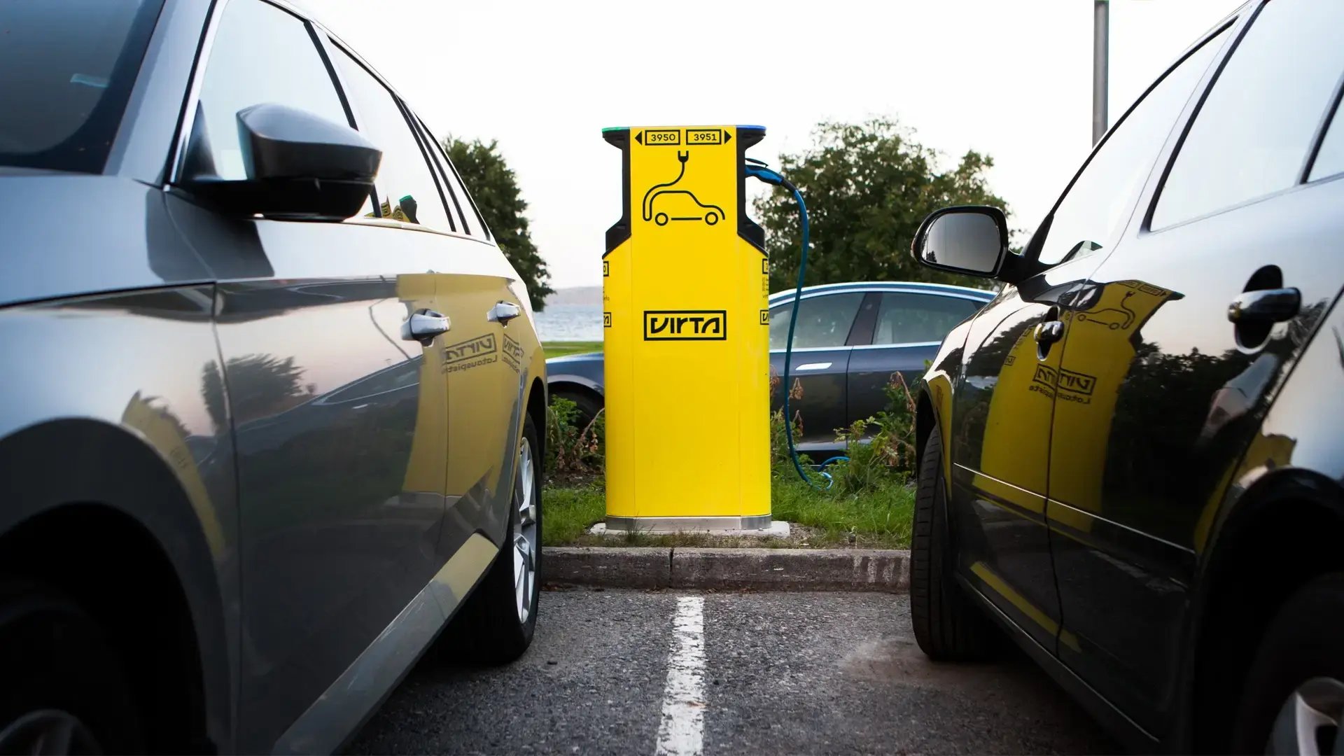 Yellow charger between two parked cars