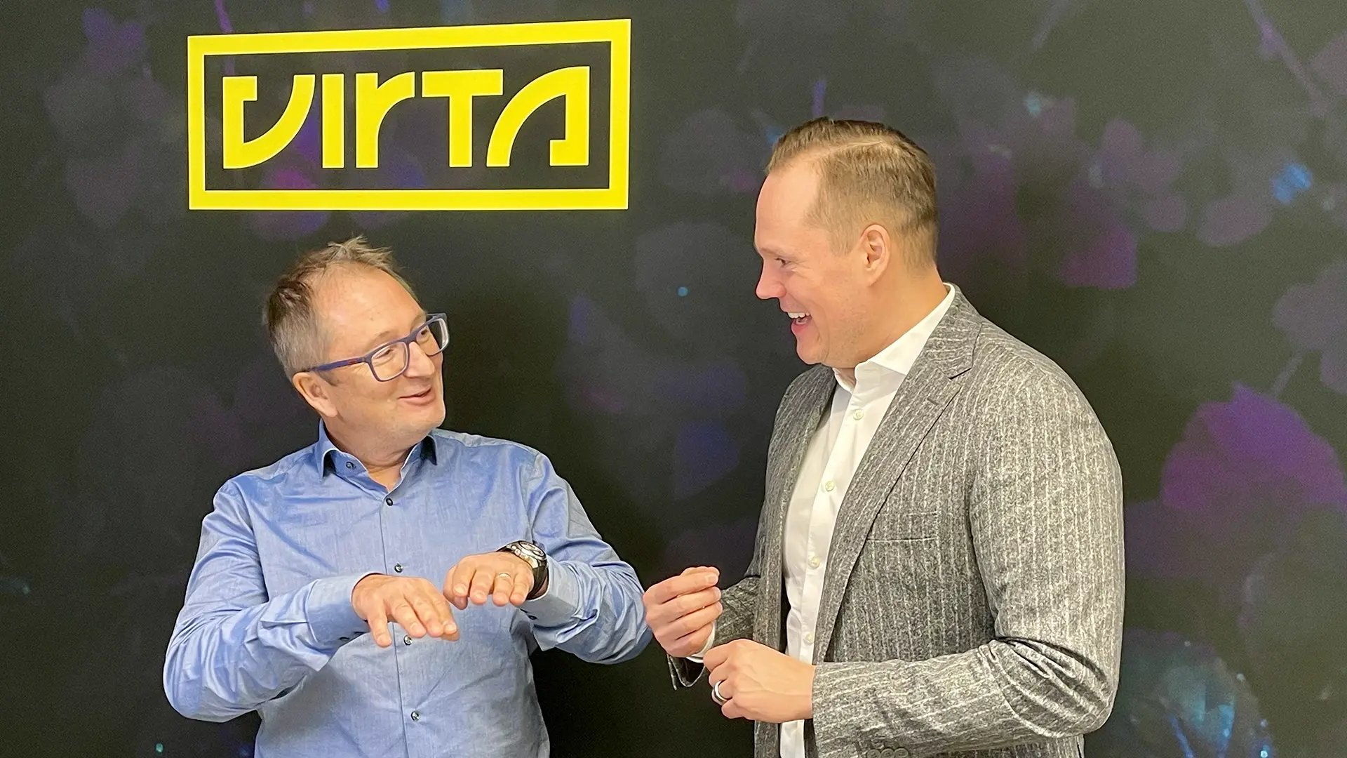 ceo-christian-girardeu-and-cio-jussi-palola-yellow-virta-logo-wall