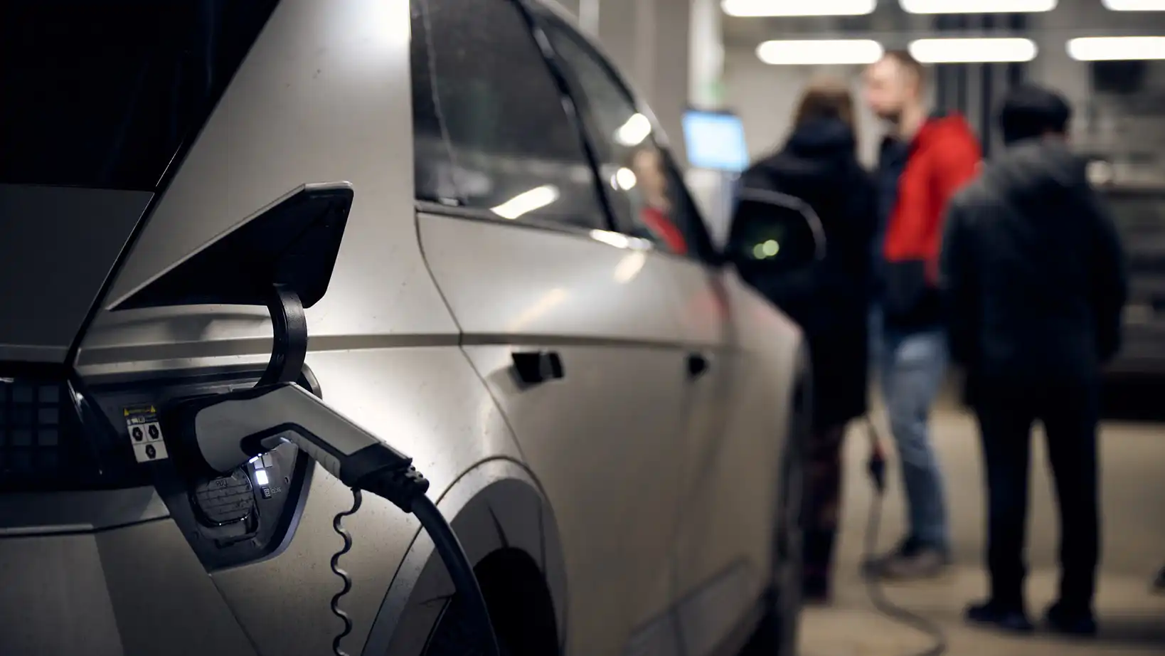 Electric vehicle with a plugged in charging cable in a garage